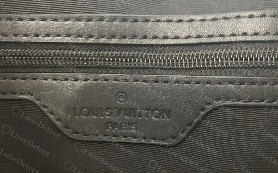 Gefälschte Keepall in unserem Archiv mit erfundener Reißverschlusstasche im Inneren und einem genähten Lederpatch mit der Prägung LOUIS VUITTON PARIS, die Buchstaben eng aneinandergedrängt