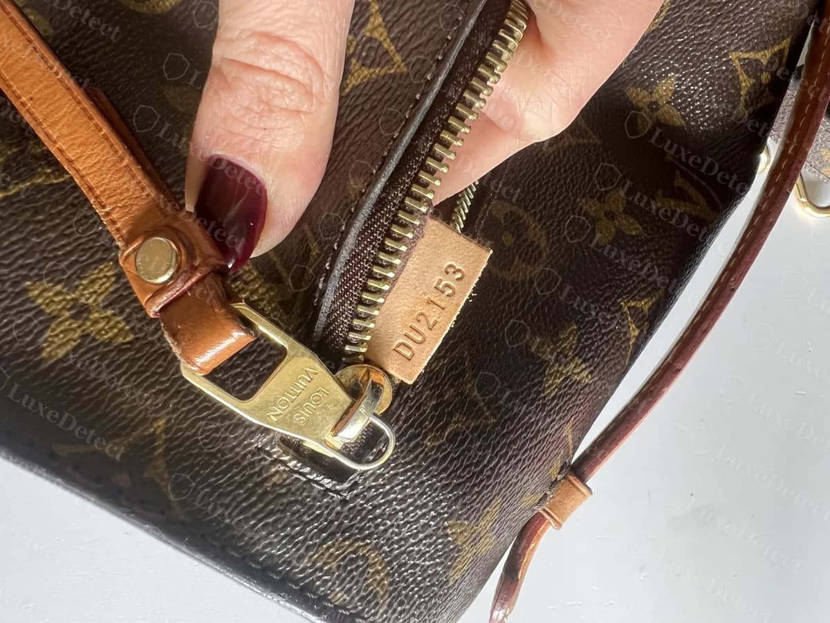 Genuine Monogram Metis with a date code "DU2153" stamped on a small vachetta tab at the end of the back zip