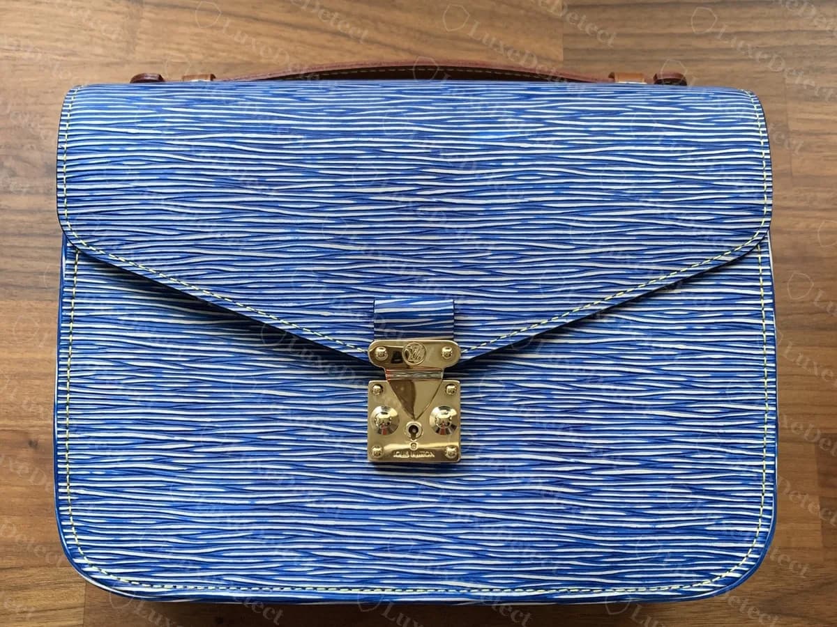 Genuine blue Epi leather Pochette Metis from the front: a flat flap with the gold-tone S-lock in the centre and a leather top handle