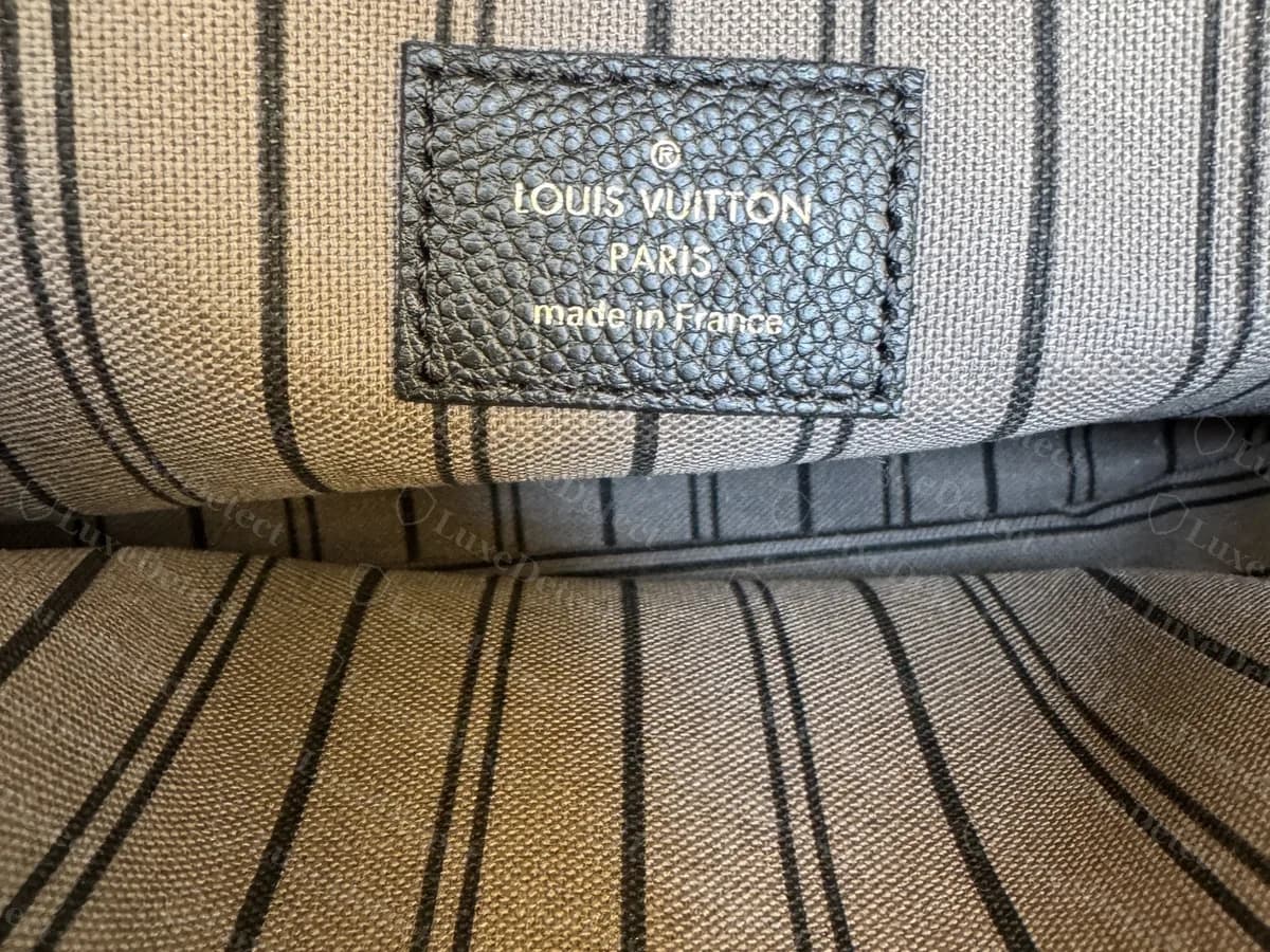 Genuine interior tab on a striped lining: a stitched dark leather tab stamped with the registered mark, "LOUIS VUITTON PARIS" and "made in France"