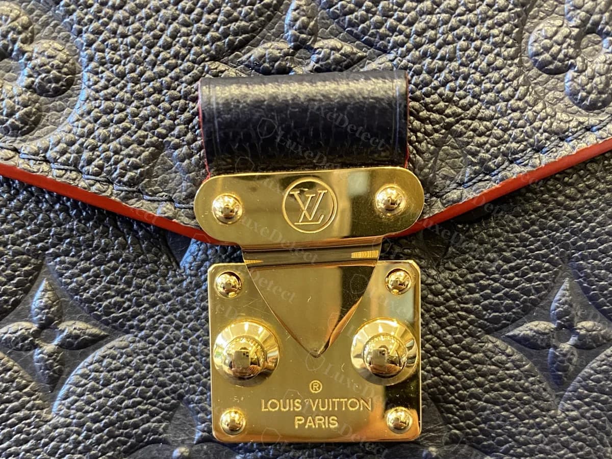 Genuine S-lock on a navy Empreinte Metis with a red painted flap edge: the same LV top plate, studs and stamped base plate
