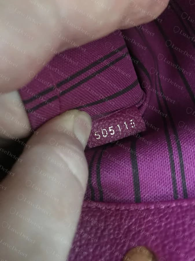 Authentic date code stamped directly onto the leather tab, no separate printed label present