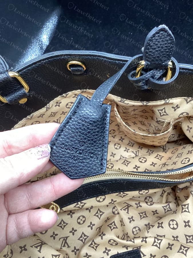 Interior of a counterfeit Montaigne in our archive, lined in a printed brown LV-monogram-pattern fabric that Louis Vuitton does not use inside this bag