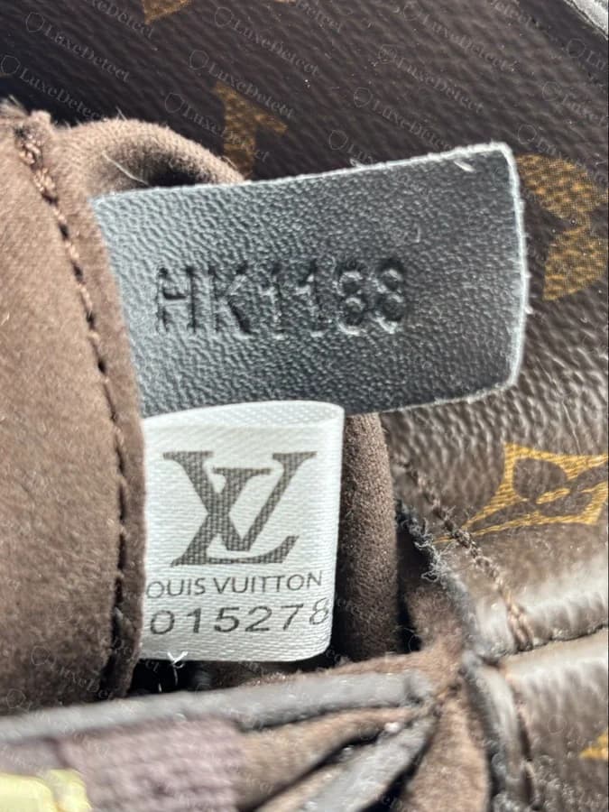 A counterfeit Montaigne in our archive with a stamped date code alongside an added printed QR-code fabric tag and numbered woven label — Louis Vuitton never uses this kind of printed authenticity tag