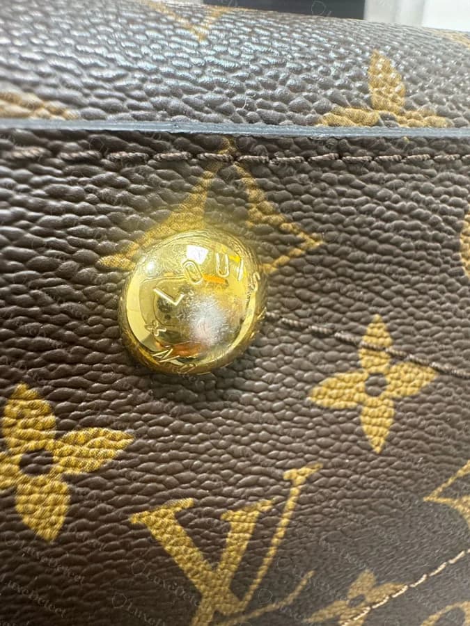 A counterfeit Montaigne base stud with crowded, unevenly struck lettering and a slightly lopsided dome