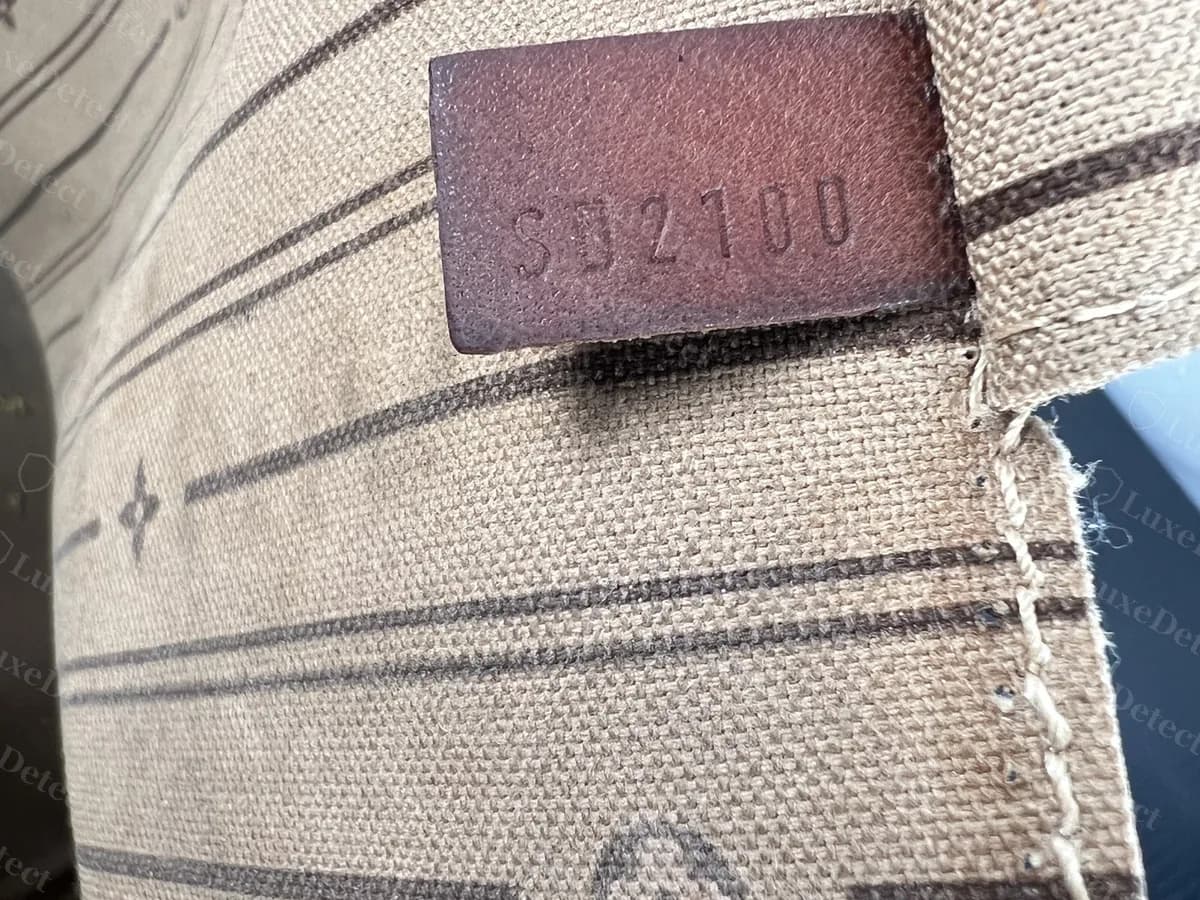 Código de fecha de una Neverfull original estampado en una pequeña etiqueta de piel cosida en la costura del forro