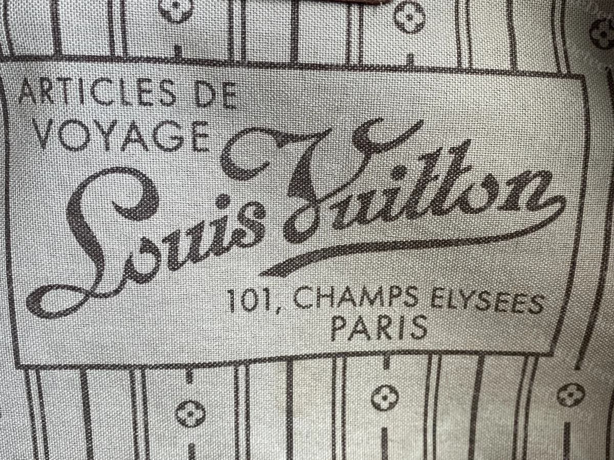 Forro mais antigo de uma Neverfull Monogram original: a etiqueta cursiva "Louis Vuitton 101, Champs-Élysées, Paris" impressa na lona listrada