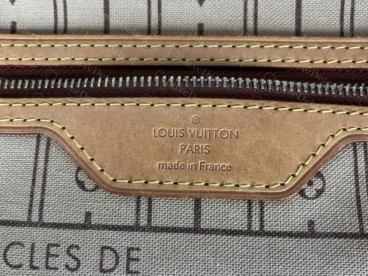 Echtes Etikett an der Innentasche einer Neverfull: "LOUIS VUITTON PARIS made in France" in das Vachetta geprägt, unter einer aufgenähten Reißverschlusstasche