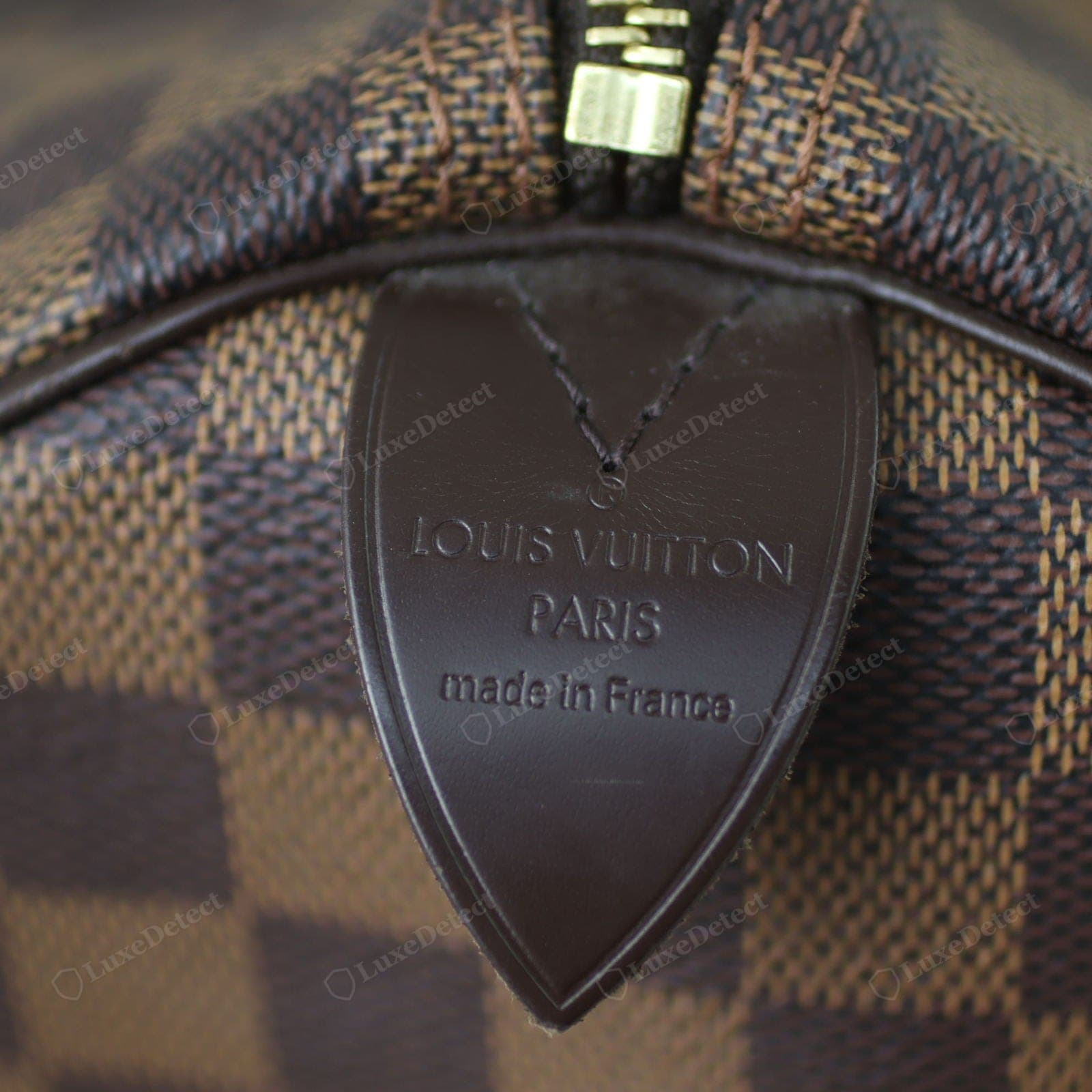 Interior leather heat stamp on an authentic Louis Vuitton bag reading LOUIS VUITTON PARIS made in France, deeply and evenly impressed