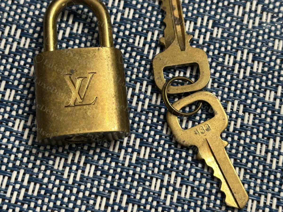 Cadenas et clés LV authentiques tels que vendus avec un Speedy : le monogramme LV sur la face du cadenas en laiton et un numéro estampé sur les clés