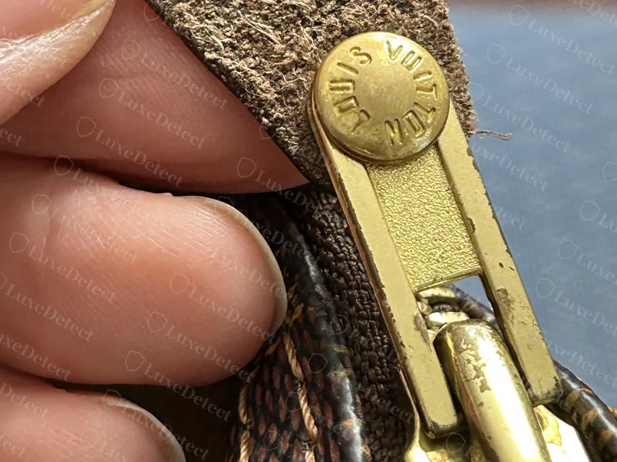 Echte Speedy-Reißverschlusszuglasche: ein Messing-Schieber mit Lederlasche, gehalten von einer Niete mit der Prägung LOUIS VUITTON