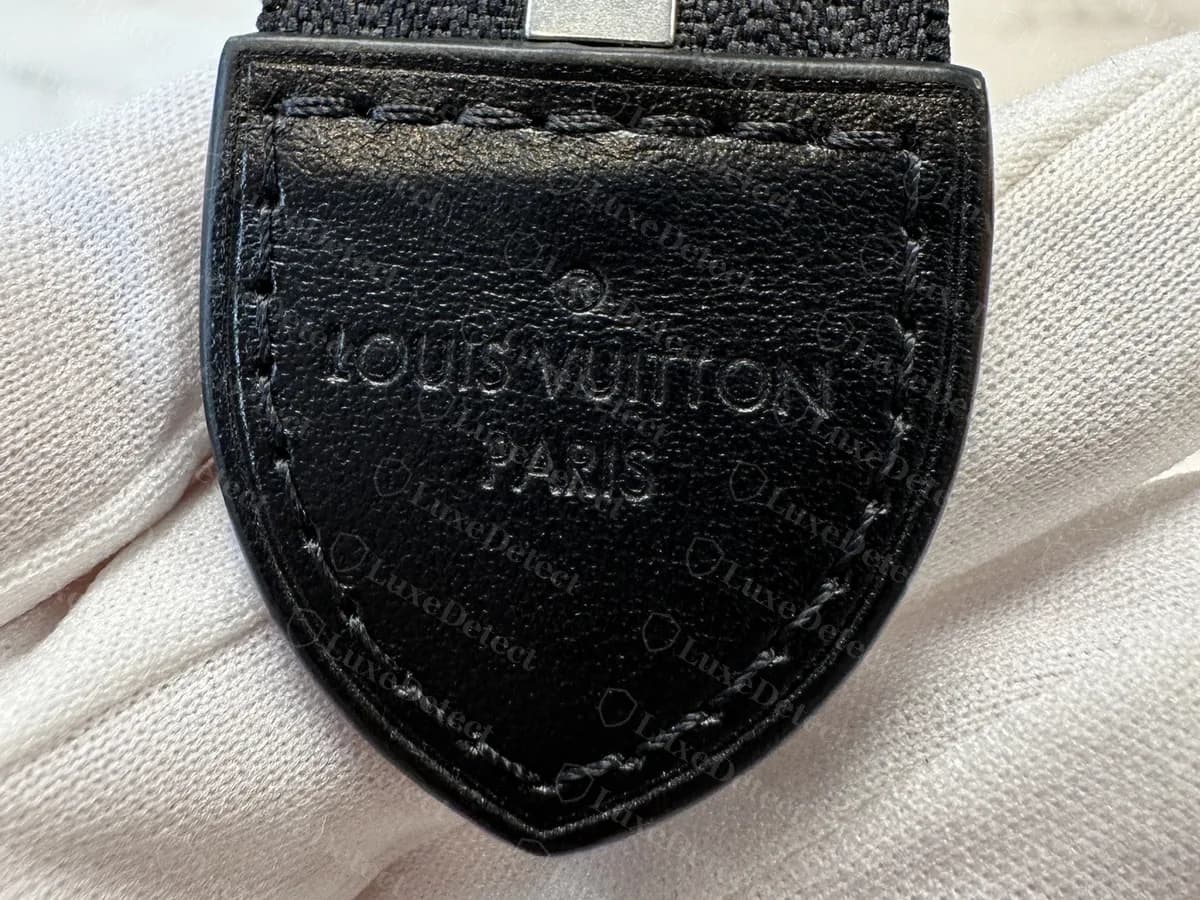 Lasche am Reißverschlussende einer echten Toiletry Pouch aus schwarzem Leder mit der Prägung LOUIS VUITTON PARIS und einem Registered-Zeichen, mit schwarzem Faden genäht, an einer Murakami-Multicolore-Pouch