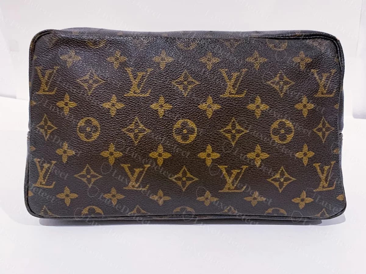Echte ältere Trousse Toilette 28 von vorn: ein kastenförmiges Monogram-Etui mit dunkel paspelierten Kanten und einem Messing-Reißverschluss oben