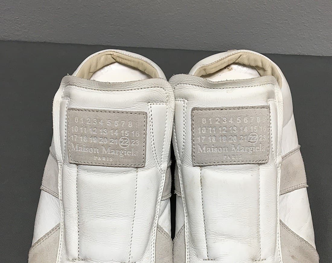 Genuine Maison Margiela heel tab — the debossed 0-23 number grid with the relevant number circled and "Maison Margiela / PARIS" printed beneath, on both shoes