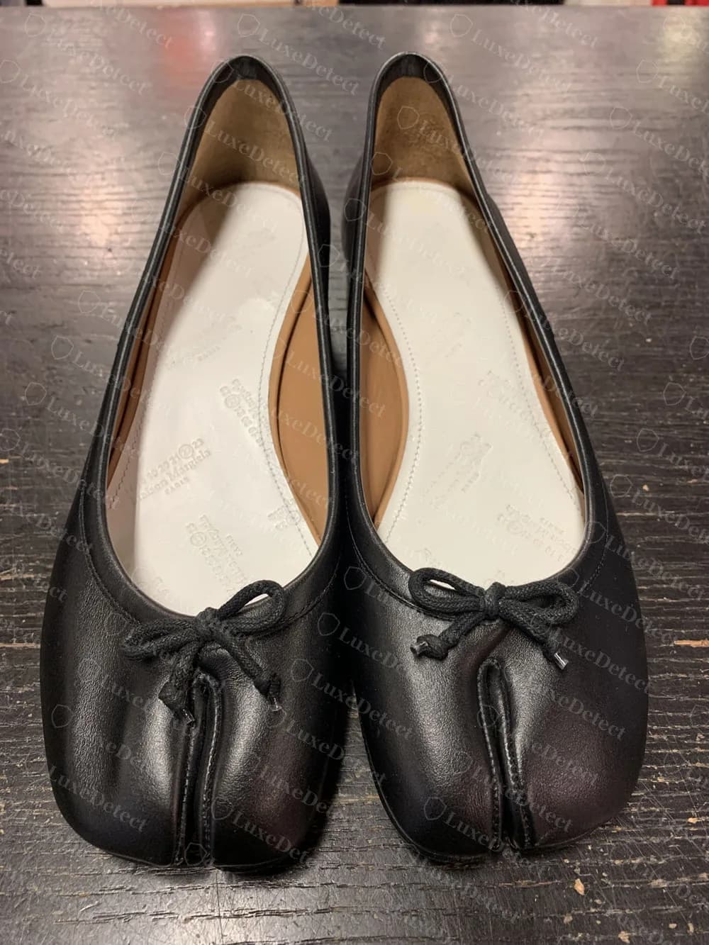 Genuine Maison Margiela Tabi ballet flats from above, black leather with a split between the big toe and the rest of the toe box and a small bow with a tied black cord on each shoe