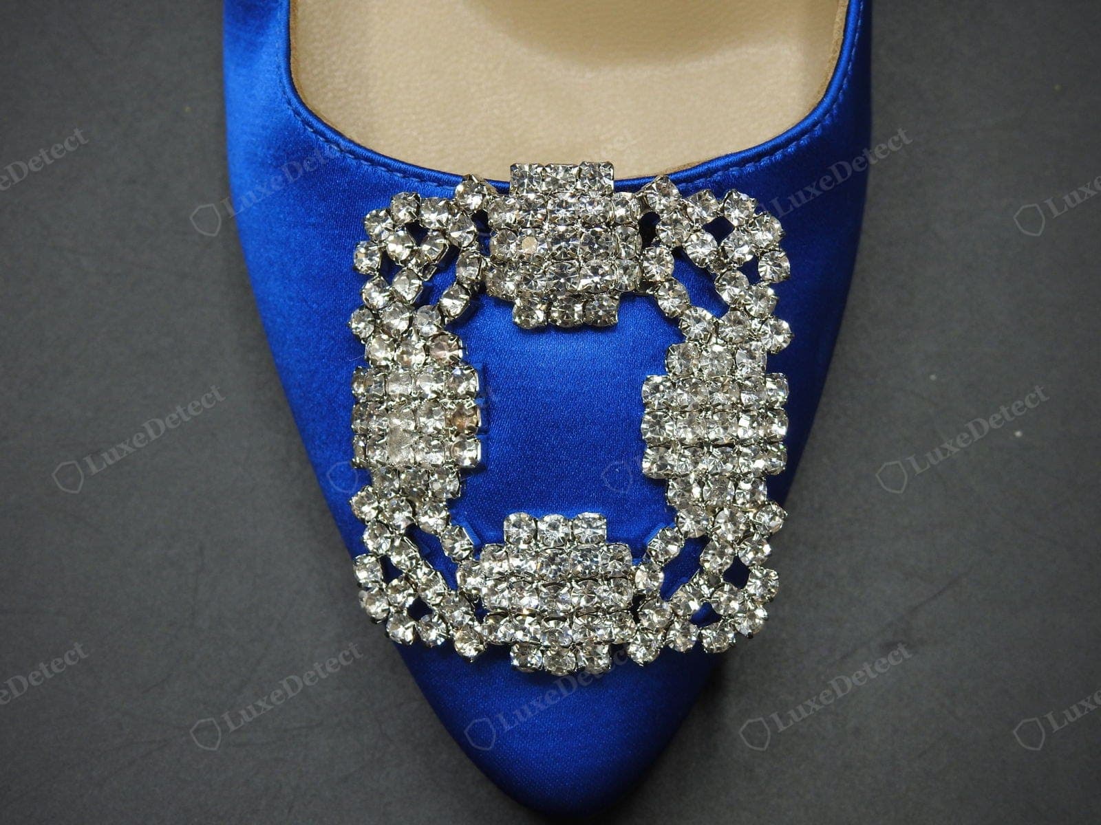 Hebilla Hangisi original de Manolo Blahnik: la hebilla rectangular con un racimo de cristales sobre satén azul cobalto, con cristales tallados, claros y brillantes engastados con garras en un denso arreglo floral, engastes plateados limpios, plana y centrada en el empeine