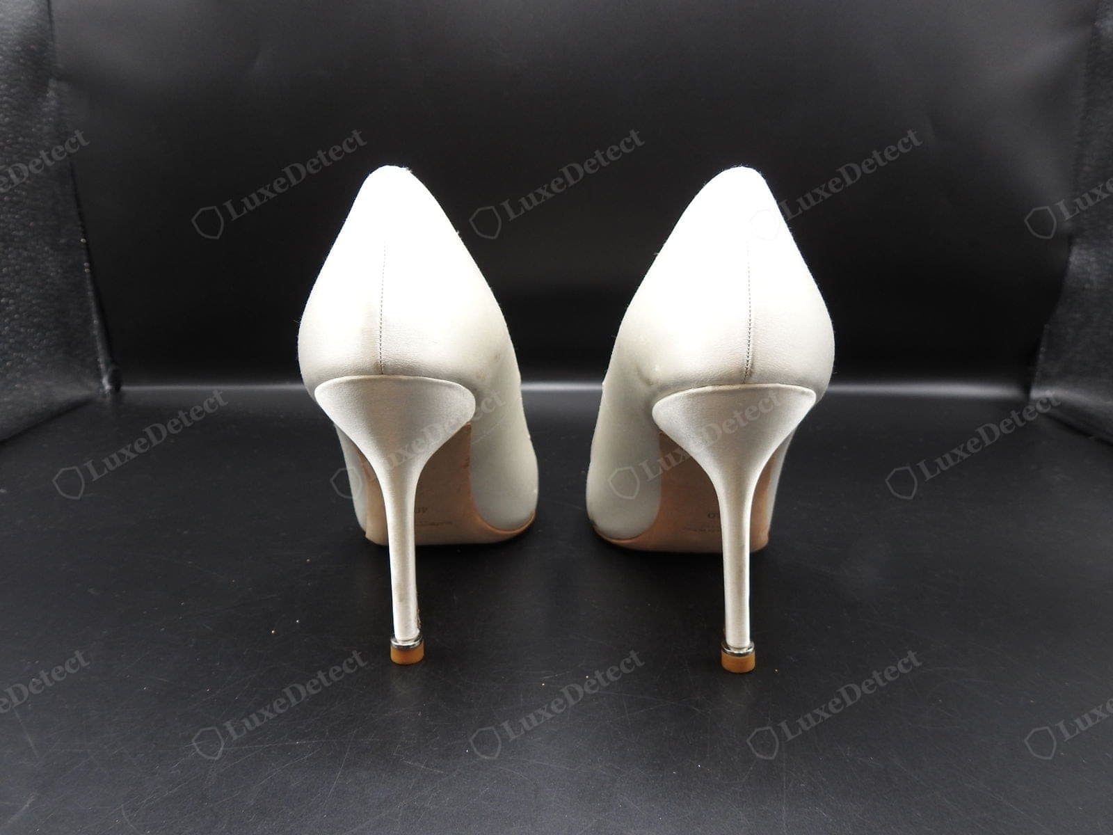 Forme authentique Manolo Blahnik — vue de dos d'escarpins en satin ivoire montrant les talons aiguilles fins et précisément inclinés, l'encolure échancrée et les deux chaussures de forme identique