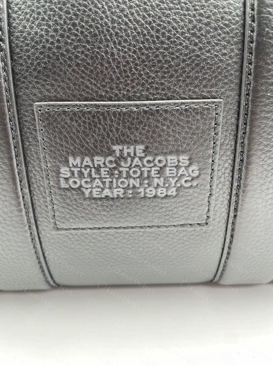 Marquage de la pièce de cuir intérieure d'un Marc Jacobs The Tote Bag authentique : « MARC JACOBS / STYLE: TOTE BAG / LOCATION: N.Y.C. / YEAR: 1984 » pressé nettement et régulièrement dans un contour proprement cousu