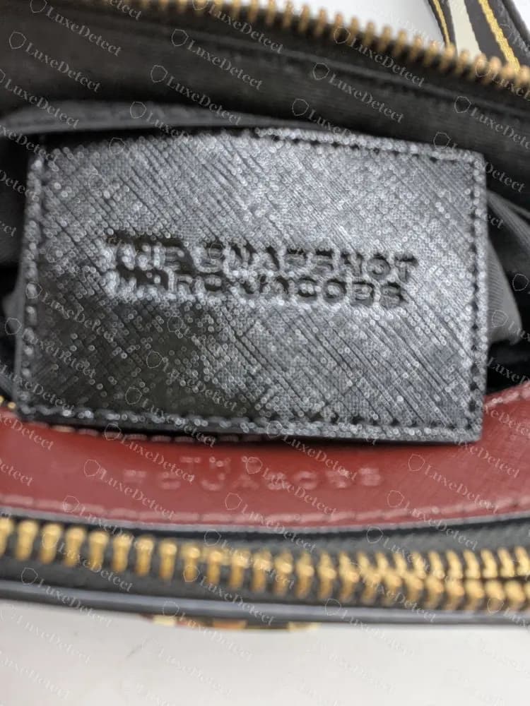 Authentic Snapshot interior patch stamped THE SNAPSHOT over MARC JACOBS, with THE MARC JACOBS on the divider strip below