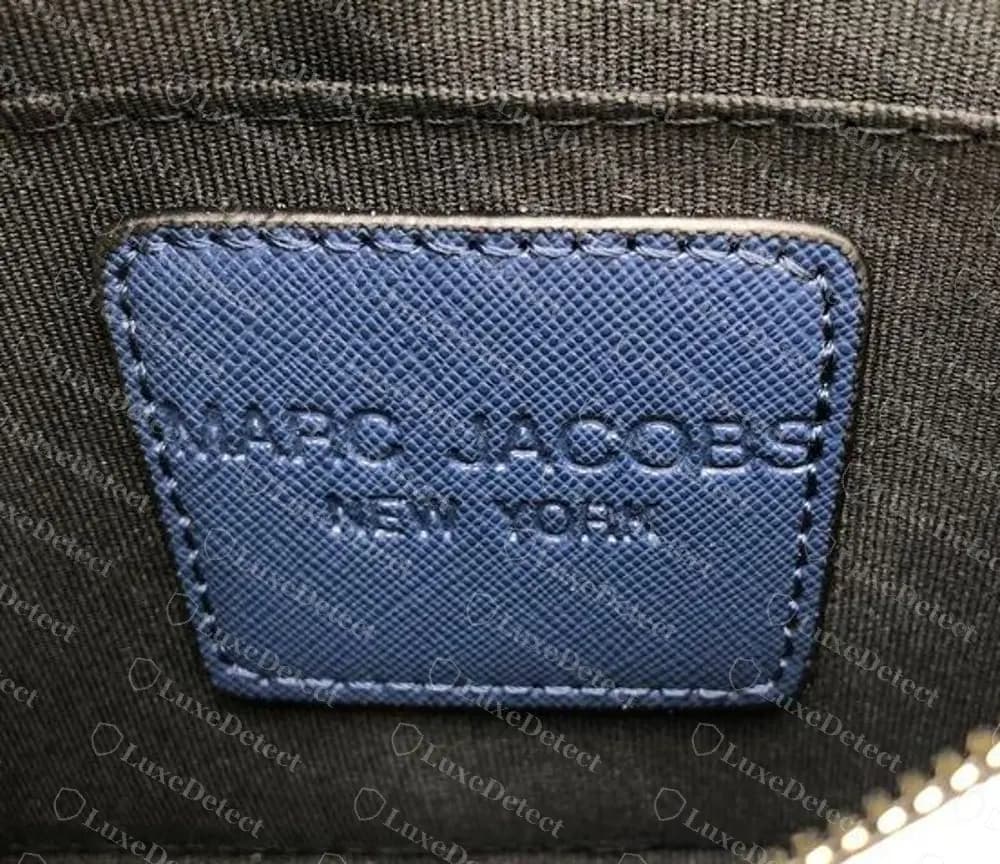 Counterfeit Snapshot interior patch stamped MARC JACOBS over NEW YORK, a wording we have only seen on fakes