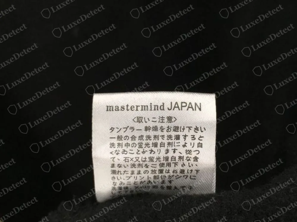 Echtes weißes Mastermind Japan Pflegeetikett mit dem Aufdruck mastermind JAPAN, einer Überschrift und darunter Zeilen mit japanischen Pflegehinweisen