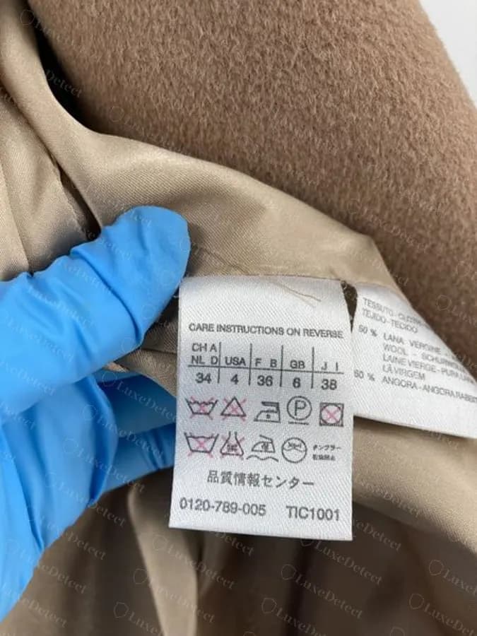 Fake MaxMara coat's composition label, printed with an "Angora" fiber content line inconsistent with this sample's genuine tags.