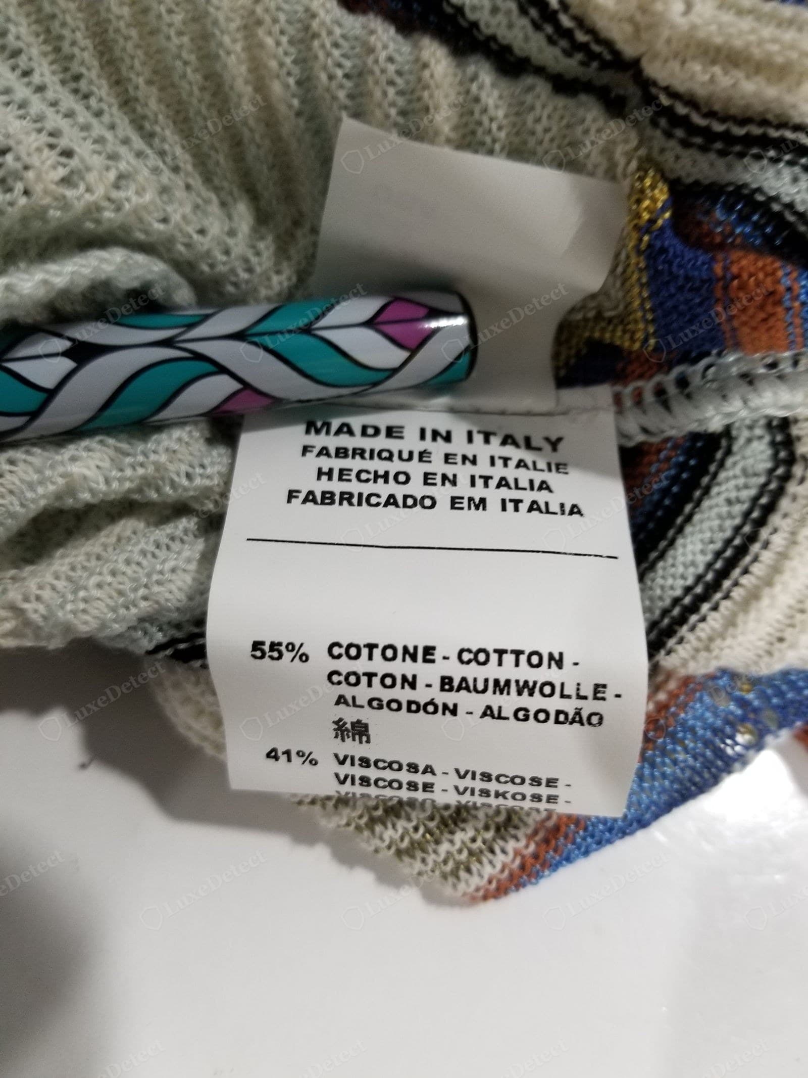 Genuine M Missoni care label — "MADE IN ITALY" in four languages and a fine-yarn fibre content (55% cotton, 41% viscose), printed cleanly on a soft white tag — the direct counterpart to the fake's "MADE IN CHINA"