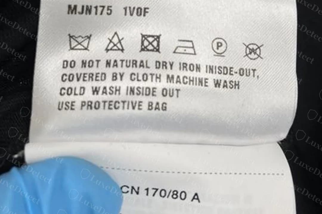Genuine Miu Miu T-shirt care label with a real printing typo: "IRON INISDE-OUT". A typo on its own does not make a label fake.