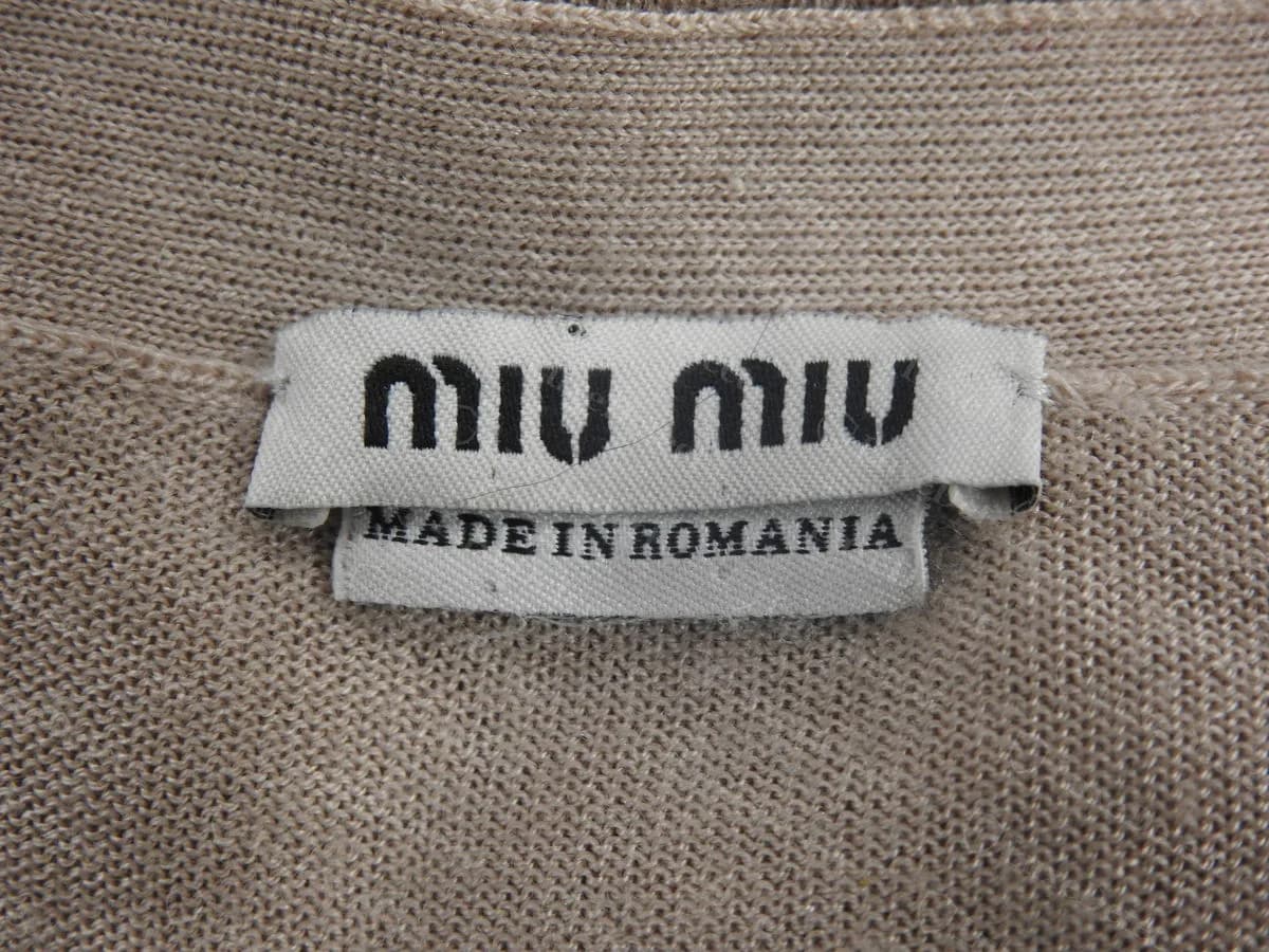 Genuine Miu Miu knit neck label reading "MADE IN ROMANIA". Origin outside Italy is normal and proves nothing either way.