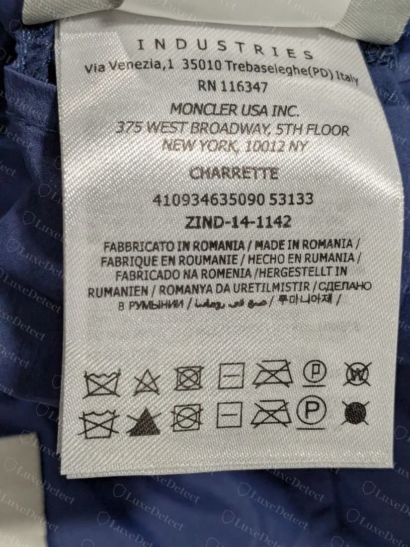 Una etiqueta de cuidado bien formada de una chaqueta declarada falsificada: dirección del fabricante, un código de producción ZIND-14-1142 y un código de estilo de 12 dígitos, sin nada en la propia etiqueta que la delate