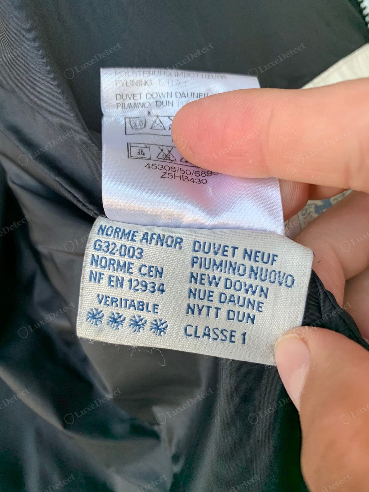 Echtes Moncler-Daunenetikett — das Etikett zu Daunenanteil und Rückverfolgbarkeit korrekt formatiert und sauber gedruckt