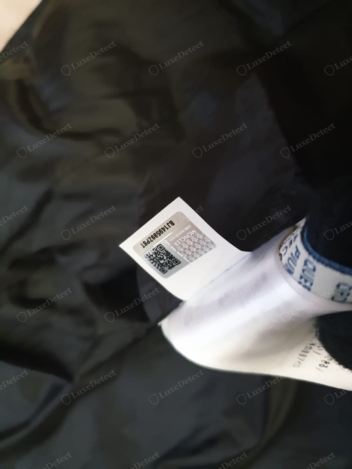 Echtes Moncler-QR-/Echtheitsetikett — das Innenetikett mit QR-Code und Hologramm sauber gedruckt und gerade eingenäht