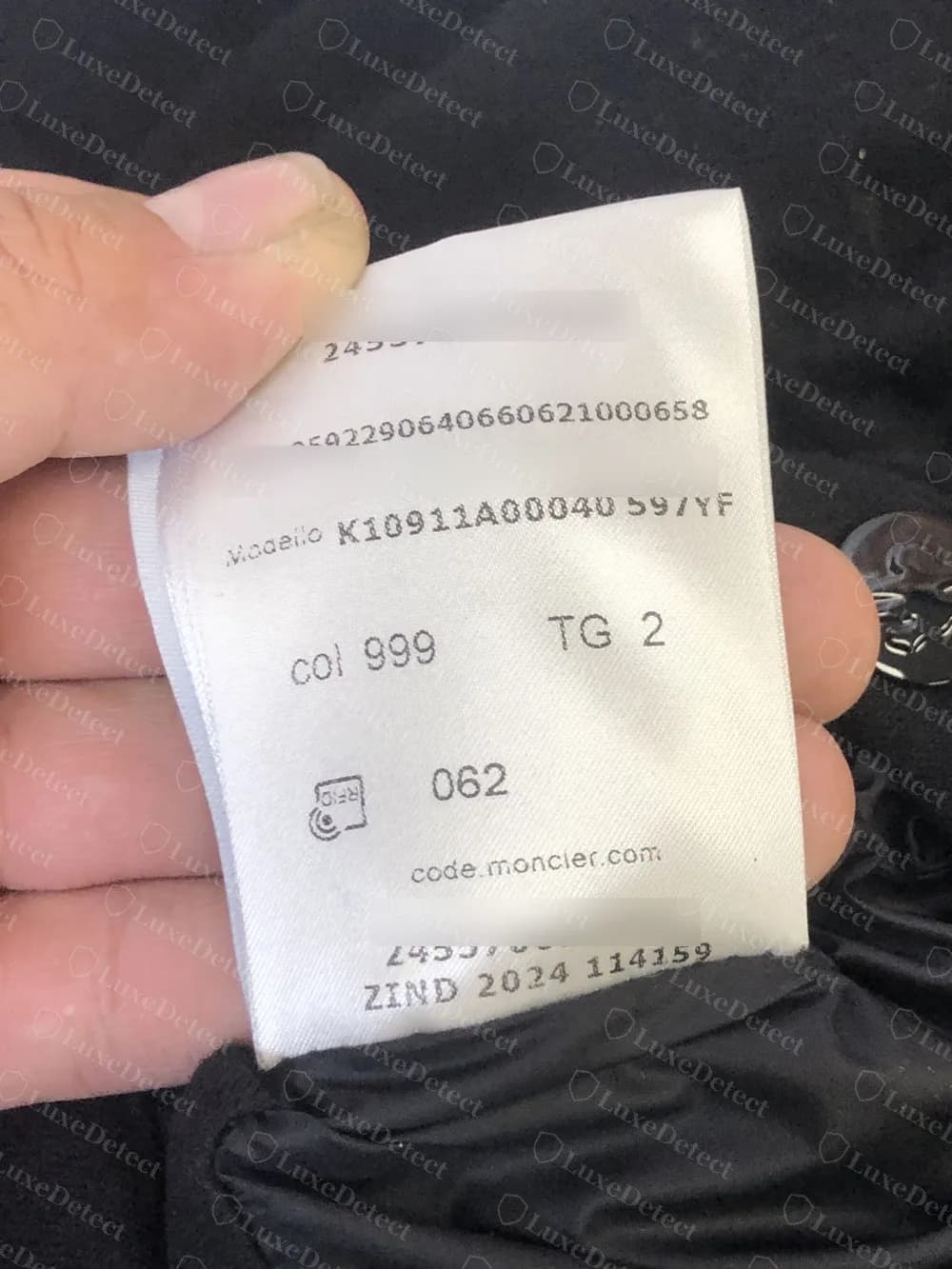 The back of a genuine 2016-onward Moncler RFID label: the Modello style code, colour, size and a production line reading ZIND 2024 114159. The authenticity code and long number have been blurred