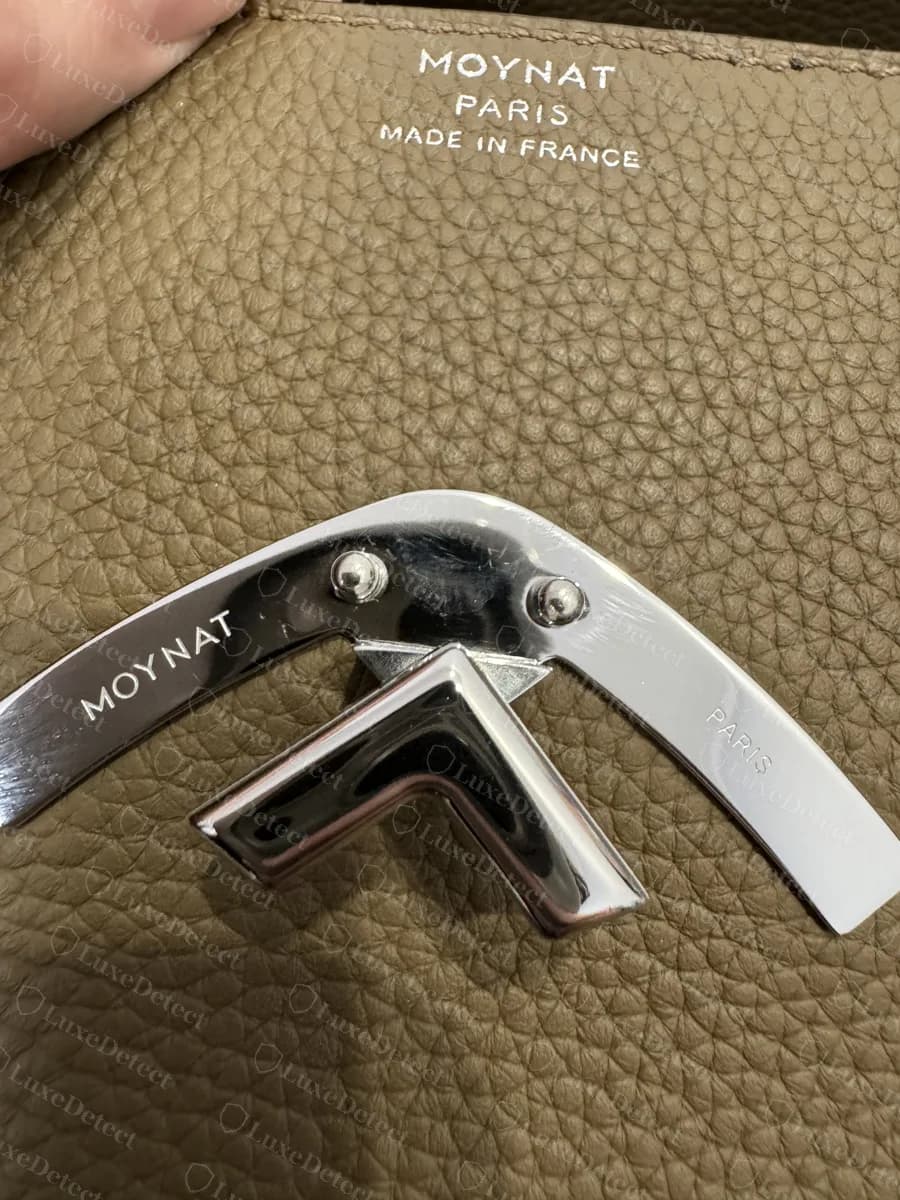 Genuine Moynat Gabrielle chevron clasp engraved MOYNAT on the left arm and PARIS on the right, with the MOYNAT PARIS MADE IN FRANCE stamp above it