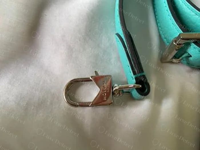 Moynat Réjane shield clasp on the shoulder strap, trapezoid plate engraved MOYNAT over PARIS with a D-ring swivel hook