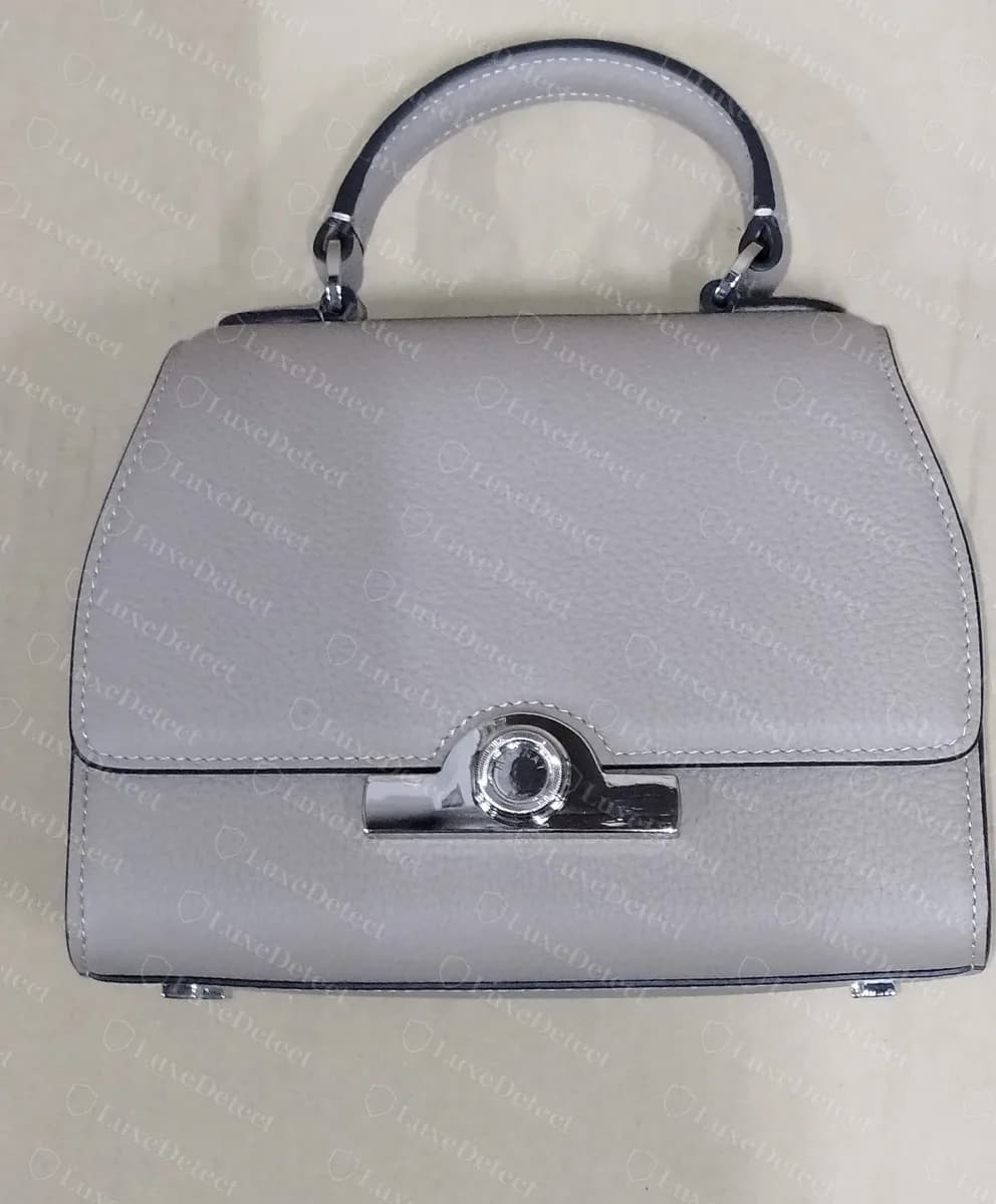 Counterfeit small gray Moynat Réjane, front view, with the trapezoid silhouette, turn-lock bridge plate and top handle all shaped correctly