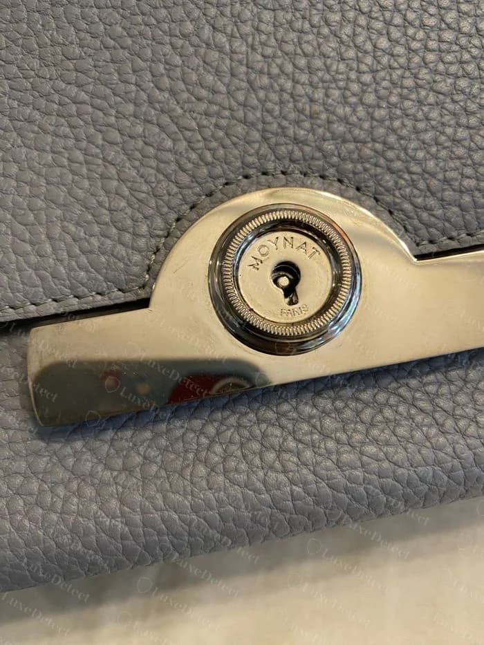 Genuine Moynat Réjane front turn-lock, MOYNAT arced above PARIS around a central keyhole, set into a polished bridge plate