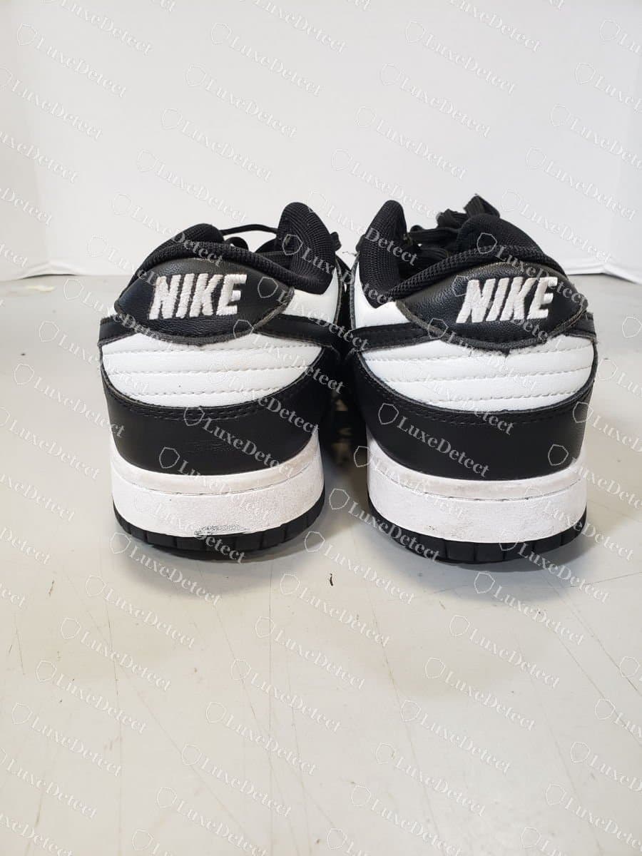 Gefälschter Nike Dunk Low Panda, Rückansicht: der gestickte „NIKE“-Schriftzug auf der Fersenlasche, mit der Naht des Fersenteils und der weißen Zwischensohle