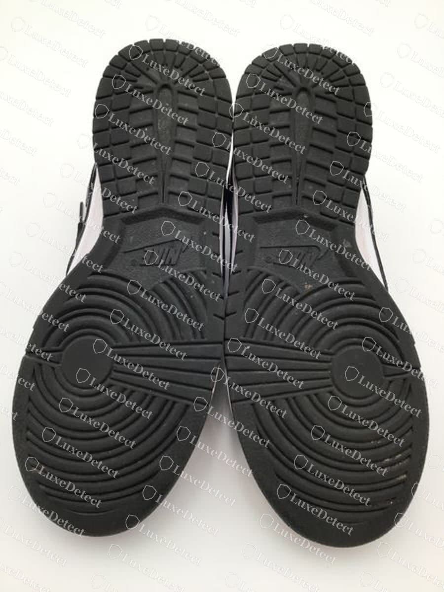 Nike Dunk Low Panda original, vista da sola: a sola externa de borracha preta com o padrão circular de pivô, os blocos de relevo em chevron e "NIKE" em baixo-relevo no arco