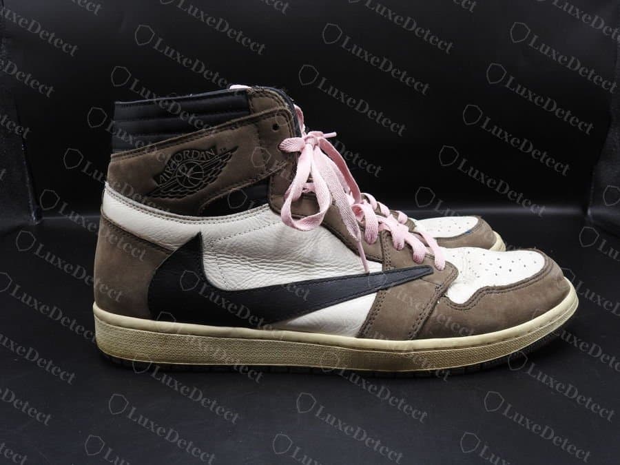 Echter Travis Scott x Air Jordan 1 High OG „Mocha“, Seitenansicht: der umgekehrte Swoosh mit nach hinten zeigender Spitze, auf dichtem braunem Nubukleder und strukturiertem weißem Leder