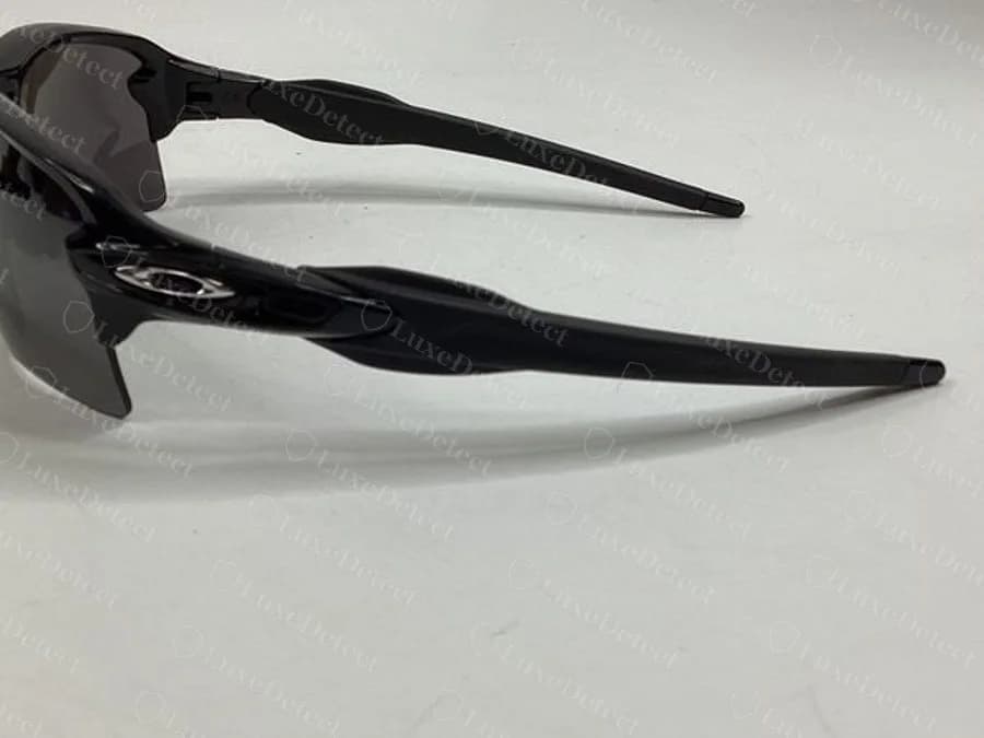 Counterfeit Oakley Flak temple stamp — the "FLAK 2.0" branding and model code at a comparable resolution to check against a listing photo
