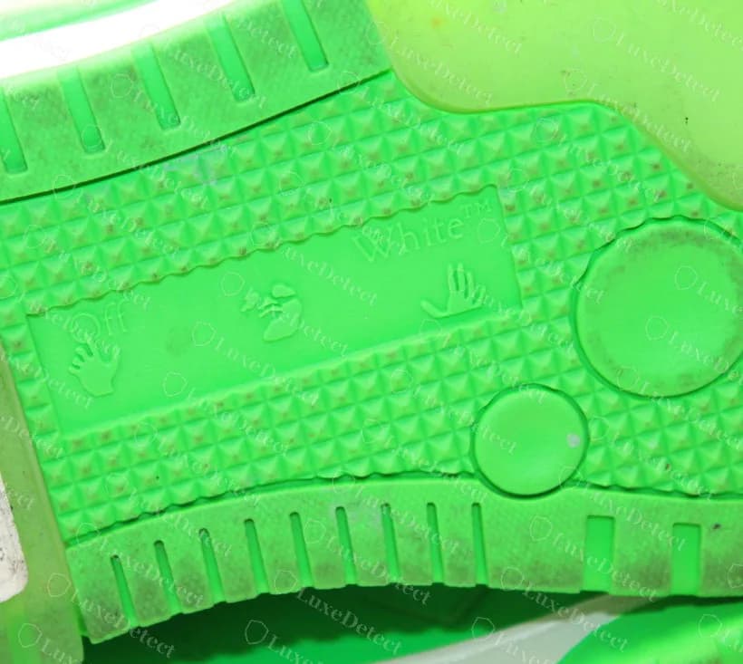Sello en la suela de una zapatilla Off-White Out of Office genuina: los iconos de la mano "Off", los labios y la mano "White" en un panel hundido; los pares falsos copian este sello