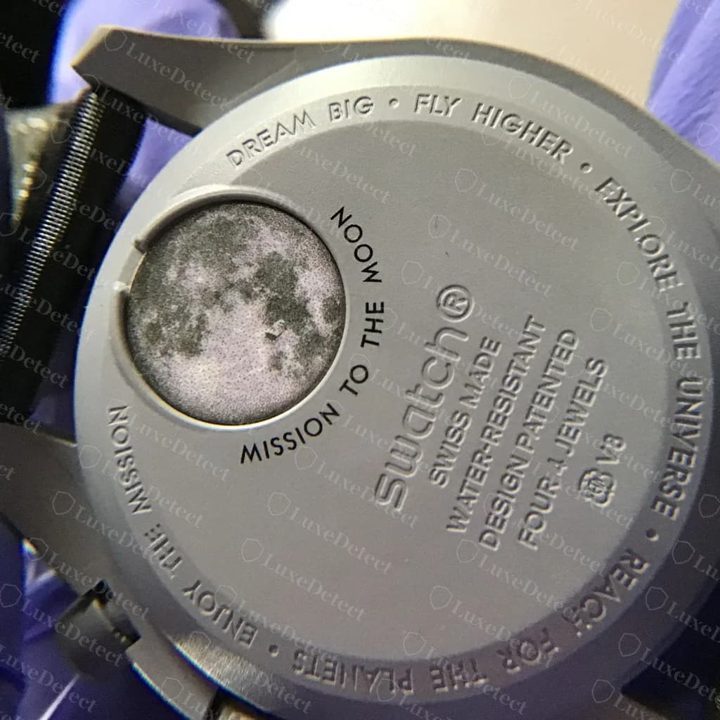 Caseback of a genuine MoonSwatch Mission to the Moon — grey Bioceramic back with the moon image, the "Mission to the Moon" text, and the Swatch name, "Swiss Made", "Four 4 Jewels" and "V8" moulded into the case
