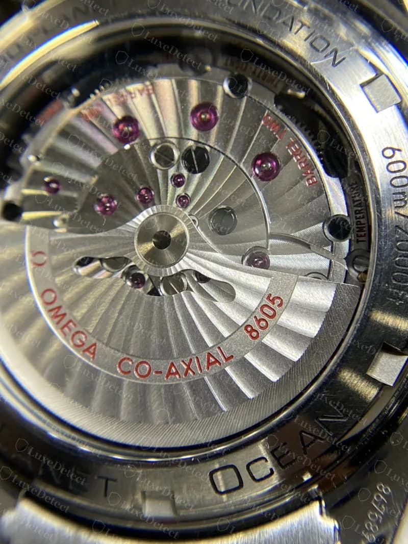 The display back of a genuine Seamaster Planet Ocean showing the Omega Co-Axial 8605 rotor, with text and numbers engraved around the rim
