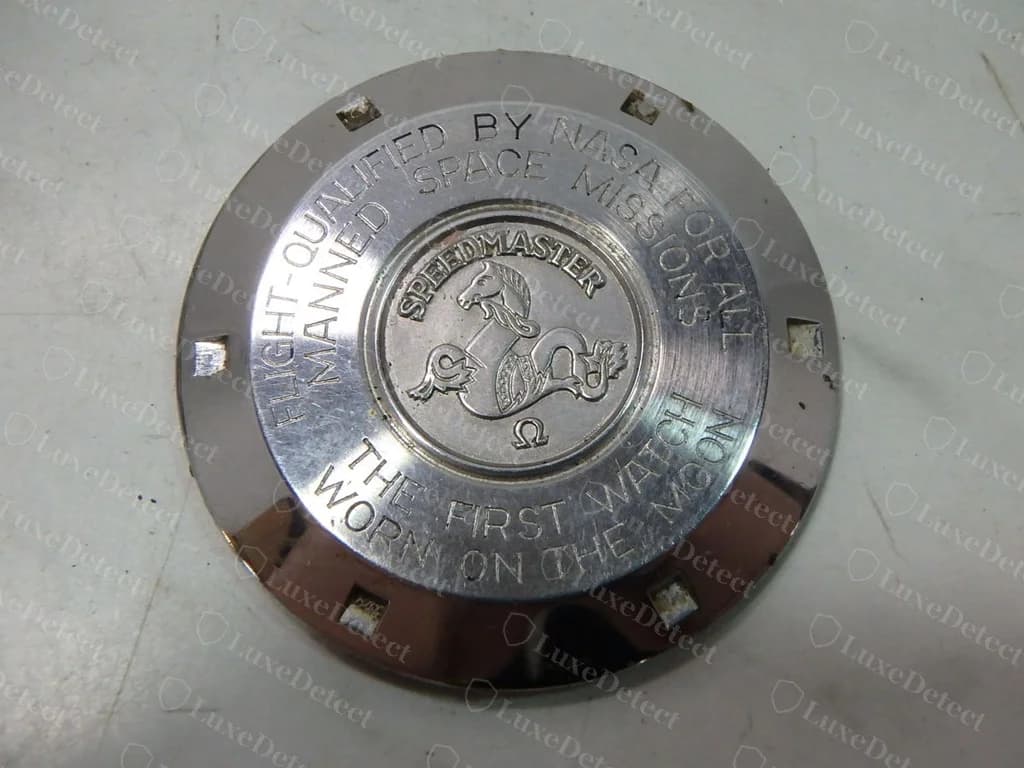 Fondo de caja de un Speedmaster Professional vintage original: "FLIGHT-QUALIFIED BY NASA FOR ALL MANNED SPACE MISSIONS" y "THE FIRST WATCH WORN ON THE MOON" alrededor de un medallón del hipocampo con la marca SPEEDMASTER