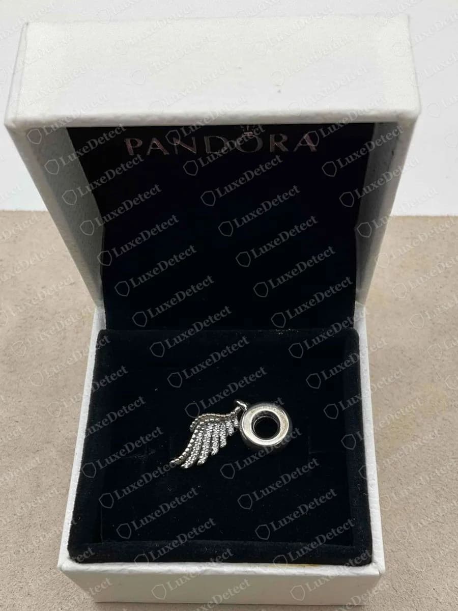 Echter Pandora Feder-Charm in der weißen Schachtel mit PANDORA auf der schwarzen Samtauskleidung