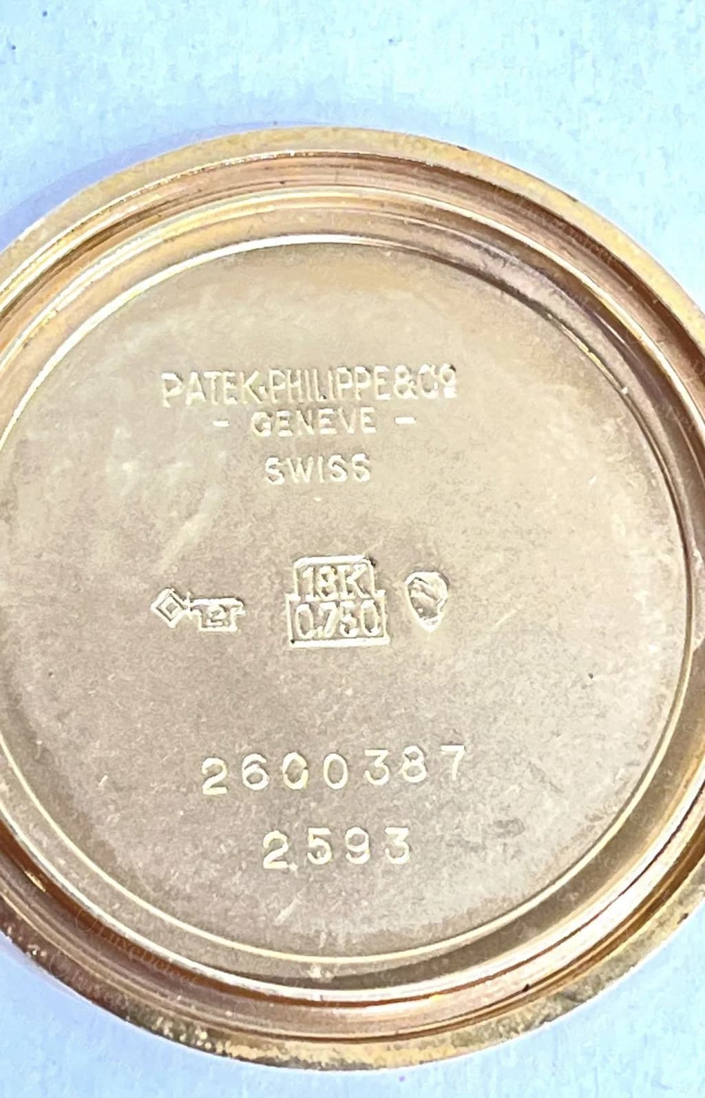 Interior del fondo de caja de un Patek Philippe vintage original de oro de 18 quilates: "PATEK PHILIPPE & Co GENÈVE SWISS", los punzones 18K 0.750, un número de caja de 7 dígitos y la referencia de 4 dígitos debajo, todo acuñado con limpieza