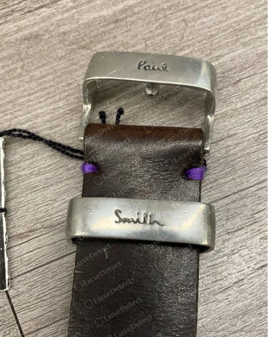 Genuine Paul Smith brown leather belt with a silver-tone buckle engraved Paul and the strap keeper engraved Smith in script, purple stitching at the fold