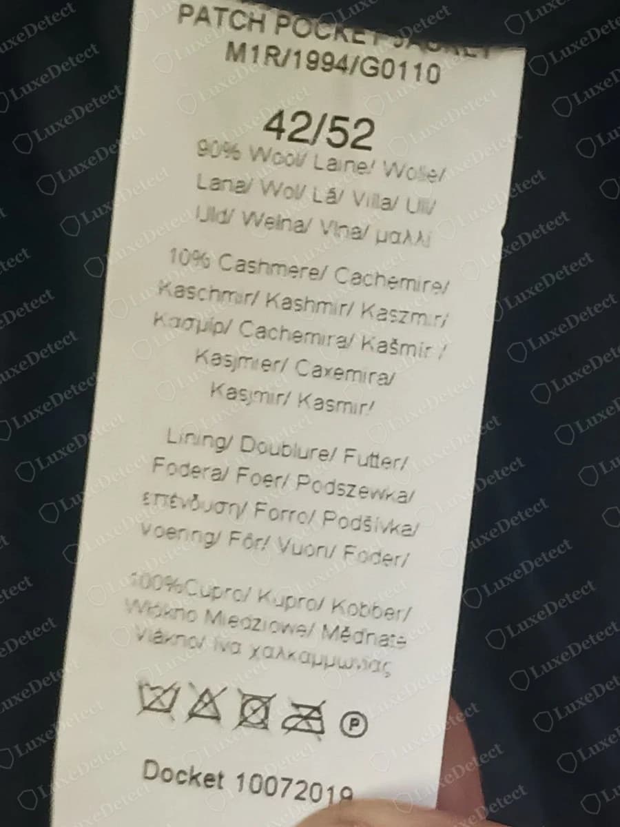 Genuine Paul Smith care label on a navy wool and cashmere jacket, listing the item name, fibre content in many languages, care symbols and a Docket line with a number
