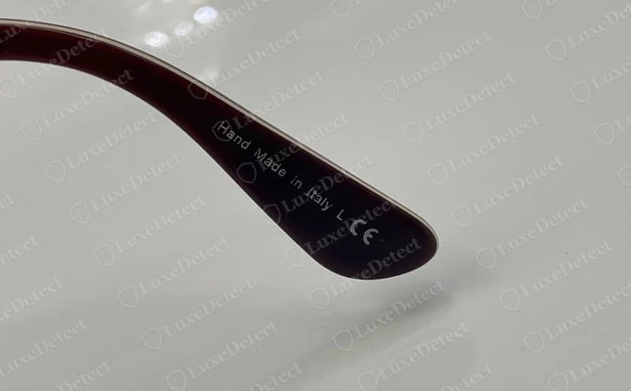 Genuine Paul Smith eyeglass temple in burgundy with Hand Made in Italy and a CE mark printed in white near the tip
